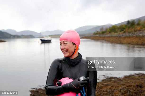 portrait of a smiling female open water swimmer by the side of a lake - cold temperature stock pictures, royalty-free photos & images