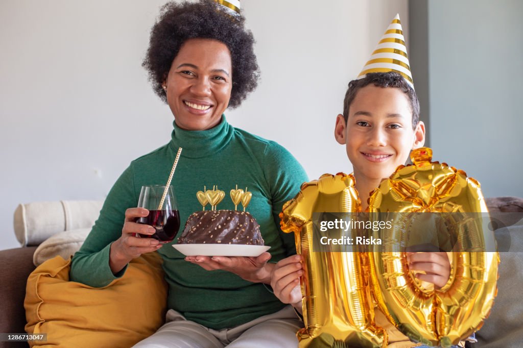 Teenager und seine Mutter feiern 10. Geburtstag zu Hause