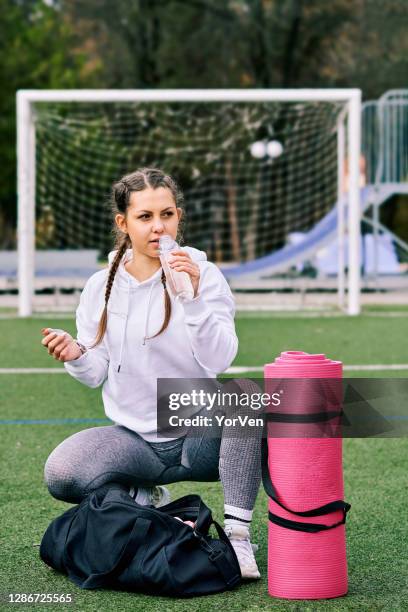 jeune femme mince attirante d’ajustement dans des sportswear se préparant à aller à l’entraînement avec un sac d’entraînement et un tapis dans la main - rollup photos et images de collection