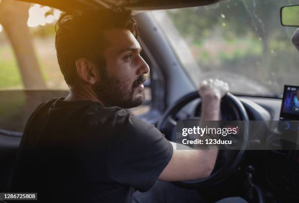 middle eastern man driving car on country road - indian ethnicity car stock pictures, royalty-free photos & images