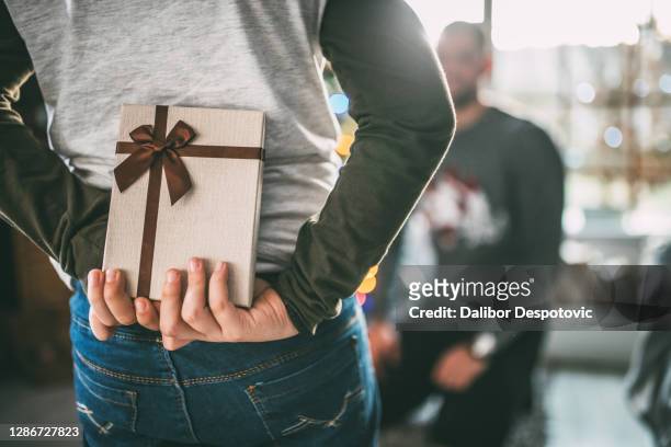 the boy holds a gift box. - hands behind back stock photos et images de collection