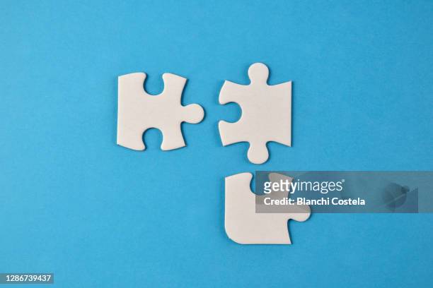 pieces of a puzzle on blue background - puzzleteile stock-fotos und bilder