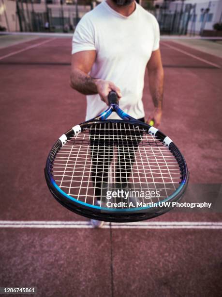 man holding a tennis racket on the court - tennis macro bildbanksfoton och bilder
