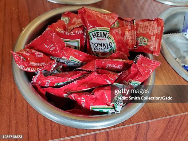 Close-up of container of Heinz brand ketchup packets in restaurant setting, Lafayette, California, November 6, 2020.