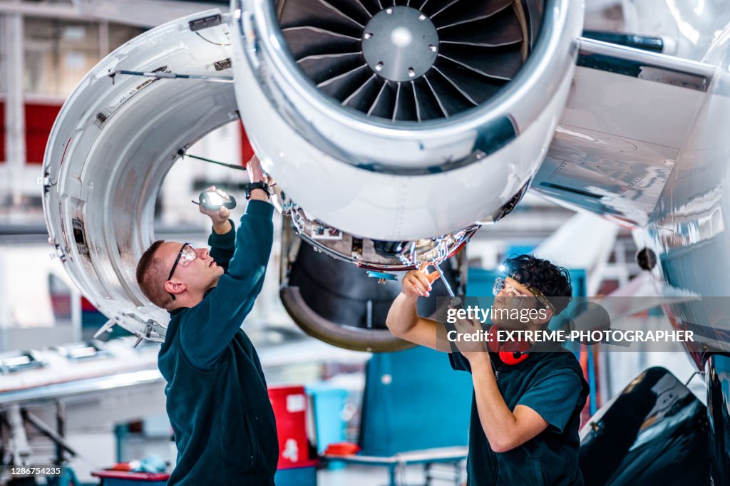 Two maintenance engineers inspecting a jet engine
