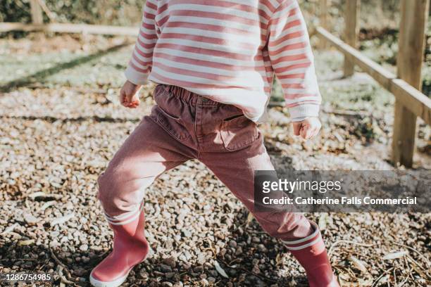 little girl dressed all in pink outdoors - rubber boots imagens e fotografias de stock