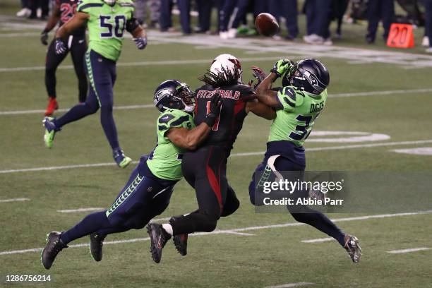 Larry Fitzgerald of the Arizona Cardinals has his pass broken up by Quandre Diggs and Bobby Wagner of the Seattle Seahawks in the fourth quarter at...