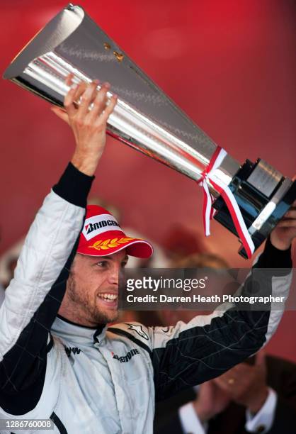 British Brawn Formula One driver Jenson Button on the winners podium holds the race winners trophy aloft in celebration of winning the 2009 Monaco...