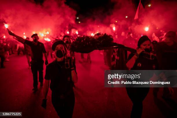 Far right-wing supporters burn red smoke flares as they take part in the 'Crown March' to commemorate the 84th death anniversary of Falange founder...