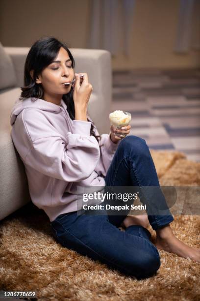 young woman at home - stock photo - mulher colher sorvete imagens e fotografias de stock