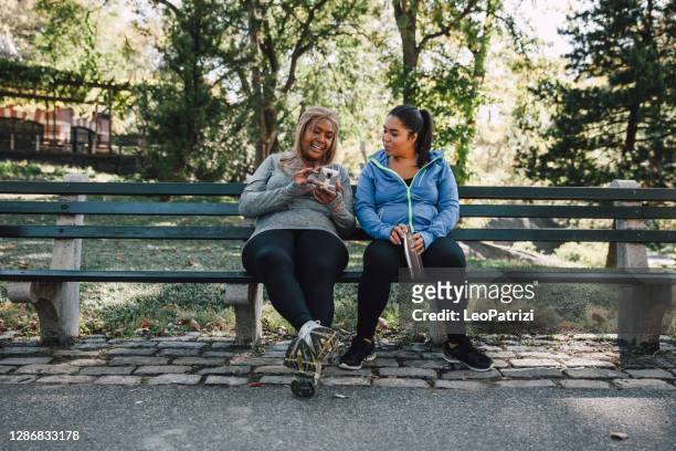 kvinnor tar en paus efter jogging i central park - central park bildbanksfoton och bilder