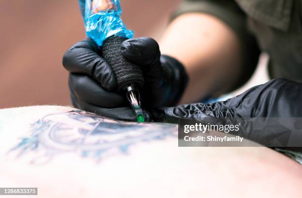 female tattoo artist making a tattoo - military parade stock pictures, royalty-free photos & images