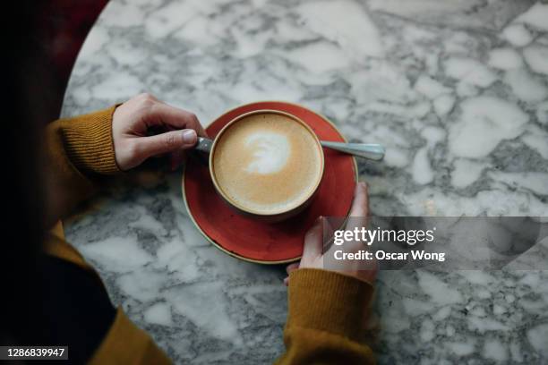 top view of woman drinking coffee at the cafe - hands resting stock pictures, royalty-free photos & images