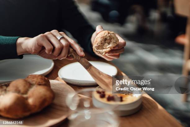 close-up shot of woman eating bread and butter for breakfast - butter knife stock pictures, royalty-free photos & images