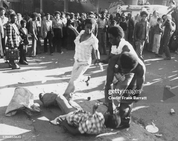 Carnival steward breaking up a fight on the streets during the Notting Hill Carnival, held across the Notting Hill district in west London, England,...