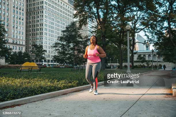 mujer recibiendo entrenamiento saludable y en forma al aire libre - black pants woman fotografías e imágenes de stock