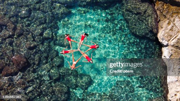 mädchen beim synchronschwimmen am strand auf mallorca - synchronized swimming stock-fotos und bilder