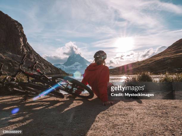 gli appassionati di mountain bike ammirano la vista dal lago riffelsee sotto il cervino - solo un uomo foto e immagini stock