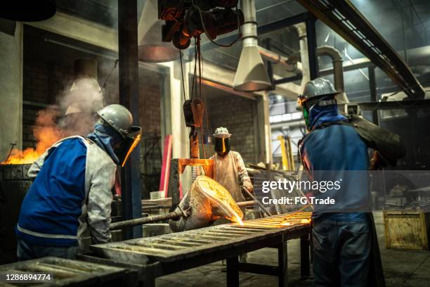 metal industry work - pouring molten metal - foundry worker stock pictures, royalty-free photos & images