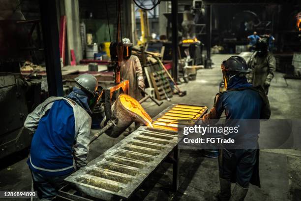 metaalindustrie werk - gieten gesmolten metaal - bruto binnenlands product stockfoto's en -beelden