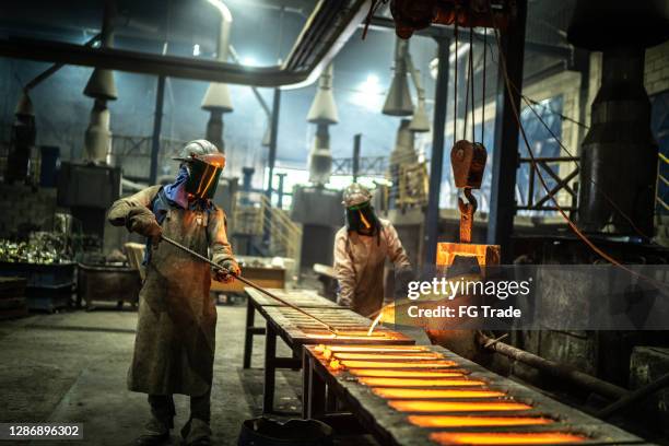 metal industry work - pouring molten metal - foundry worker stock pictures, royalty-free photos & images