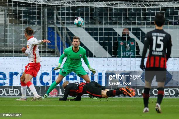 Yussuf Poulsen of Leipzig scores his team's first goal against goalkeeper Kevin Trapp of Frankfurt during the Bundesliga match between Eintracht...