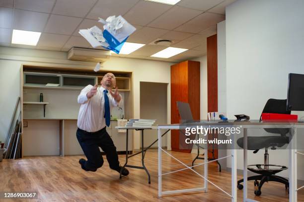 männlicher mitarbeiter stolpert an einem tisch und fällt papiere fallen, wie er in einem büro fällt 1of2 - broken cup stock-fotos und bilder
