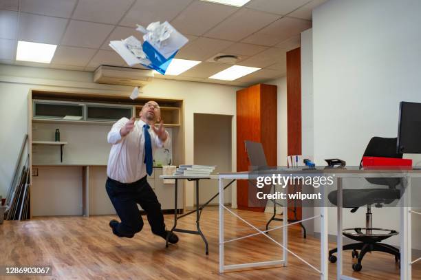 mannelijke werknemer die bij een lijst struikelt en documenten laat vallen aangezien hij in een bureau 1of2 valt - broken laptop stockfoto's en -beelden