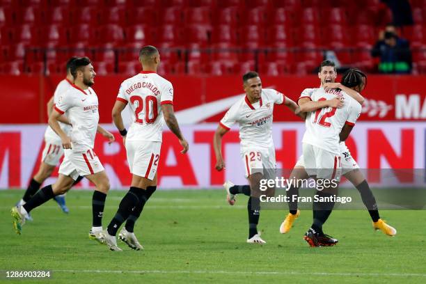 Sergio Escudero of Sevilla celebrates with teammate Jules Kounde after scoring his team's third goal during the La Liga Santander match between...