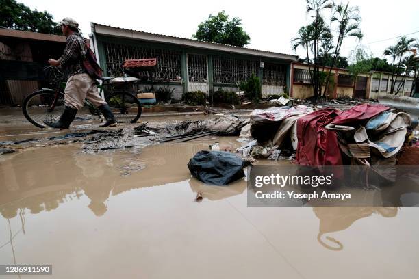 Man walks with his bicycle through a street covered with mud and debris caused by Hurricane Iota floodings at Colonia Celeo Gonzales on November 21,...