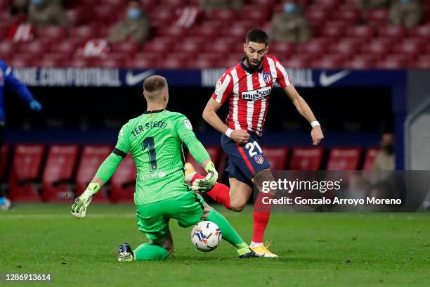 Yannick Carrasco of Atletico de Madrid runs with the ball past Marc-Andre ter Stegen of FC Barcelona on his way to scoring his team's first goal...