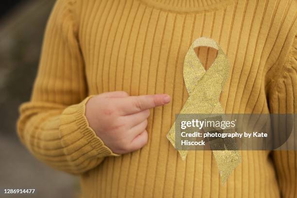 gold awareness ribbon - cancer infantil fotografías e imágenes de stock