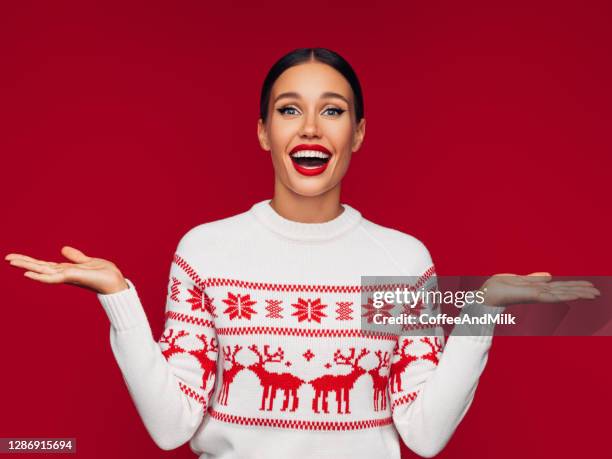 mooie vrouw die met haar handen gesturing - christmas sweater stockfoto's en -beelden