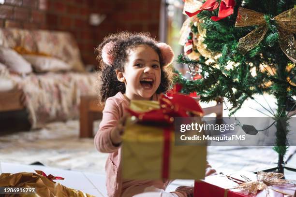 happy girl holding christmas gift box - receiving present stock pictures, royalty-free photos & images