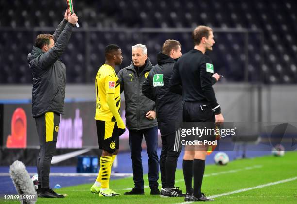 Head coach Lucien Favre of Dortmund talks to Youssoufa Moukoko before he replaces Erling Haaland during the Bundesliga match between Hertha BSC and...