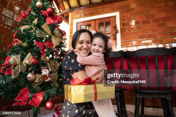 mother and daughter hugging at christmas - tia imagens e fotografias de stock