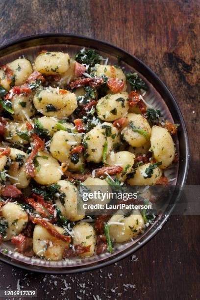 gnocchi mit knuspriger pancetta, sonnengetrockneten tomaten und spinat - sonnengetrocknete tomate stock-fotos und bilder