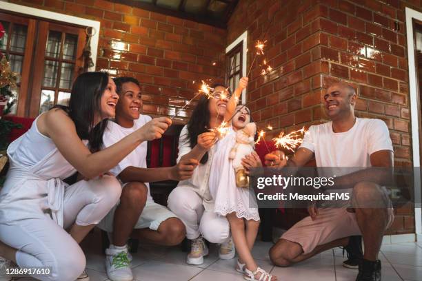 family celebrating new year with sparklers - new year imagens e fotografias de stock