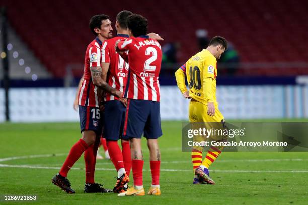 Stefan Savic, Felipe, and Jose Gimenez of Atletico de Madrid celebrate following their team's victory, as Lionel Messi of FC Barcelona looks dejected...