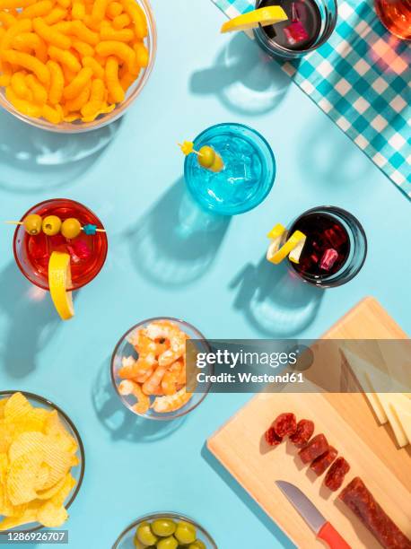 blue table set with various snacks, appetizers and cocktails - blue bowl foto e immagini stock