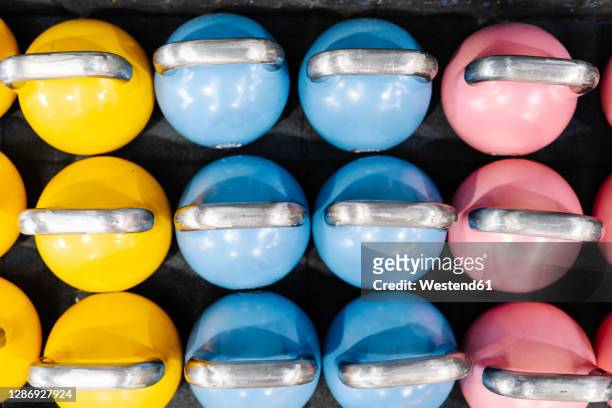 close-up of colorful kettlebells on table in gym - large group of objects sport stock pictures, royalty-free photos & images