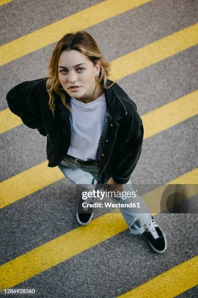 young woman standing on street - elevated view portrait stock pictures, royalty-free photos & images