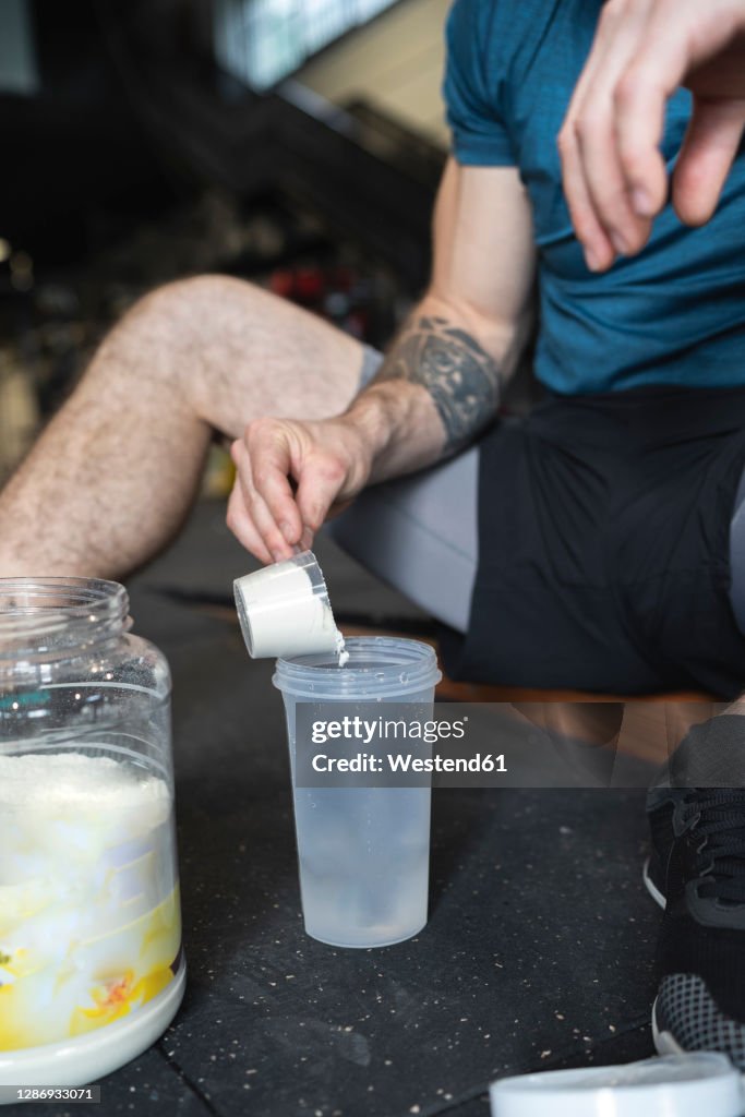 Close-up of sportsman making protien shake