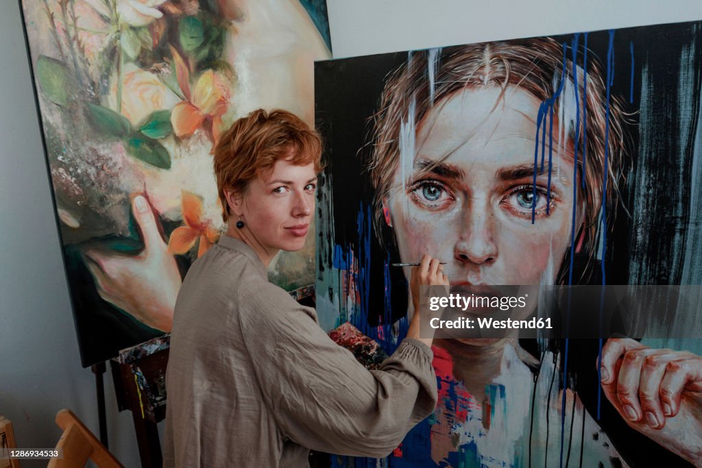 Female artist painting on canvas in studio