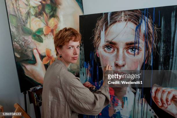 female artist painting on canvas in studio - pittore artista foto e immagini stock