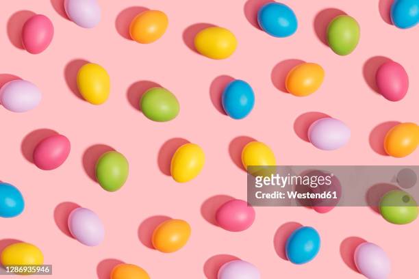 multi colored easter eggs on pink background - easter egg stock pictures, royalty-free photos & images