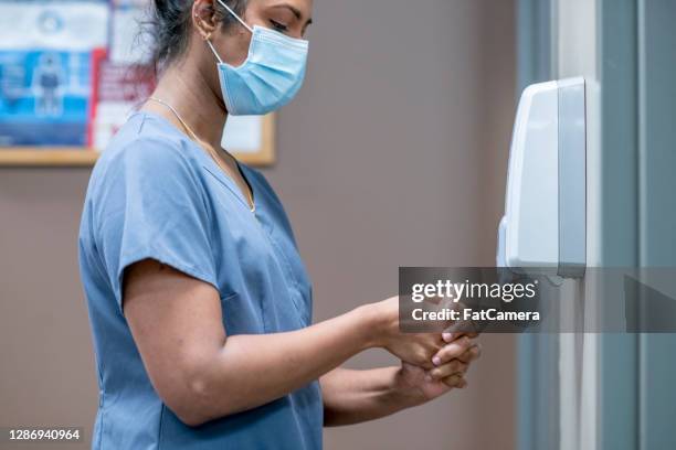 enfermeira higieniza mãos - hand sanitiser - fotografias e filmes do acervo