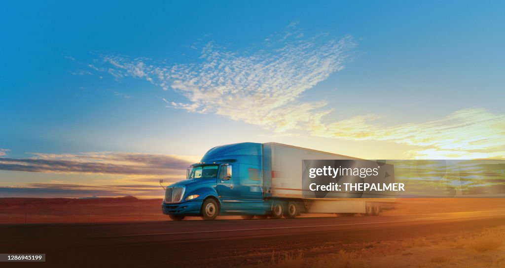 Blauw-witte semi-vrachtwagen die op één enkele steegweg de V.S. versnelt