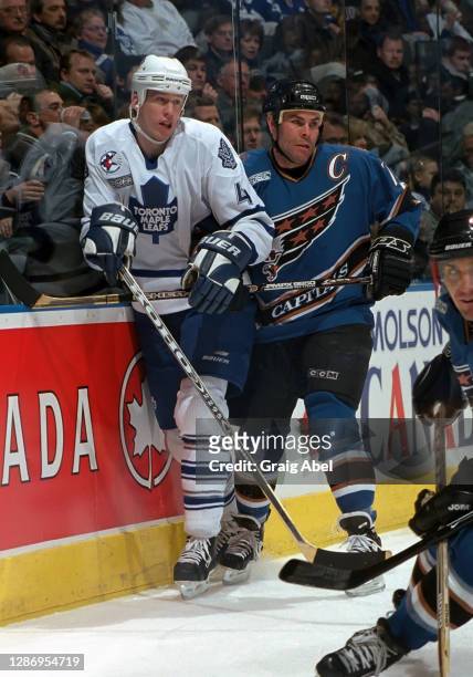 Adam Oates of the Washington Capitals skates against Cory Cross of the Toronto Maple Leafs during NHL game action on January 22, 2000 at Air Canada...