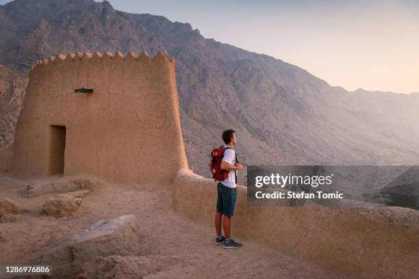 man visiting dhayah fort in north ras al khaima in the uae - jebel hafeet stock pictures, royalty-free photos & images